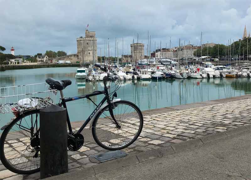Bicicleta atada a un poste frente al puerto de La Rochelle 