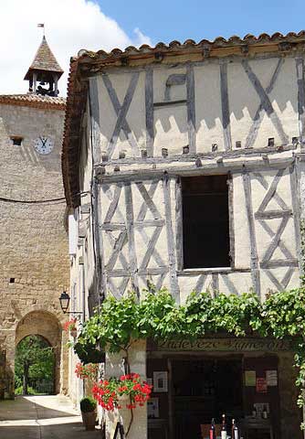Casa con entramado de madera y torre del reloj medieval en el hermoso pueblo de Fources, Gers