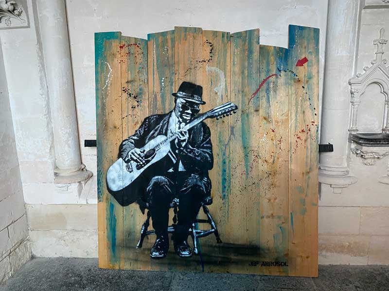 Pintura de un músico de blues tocando la guitarra.