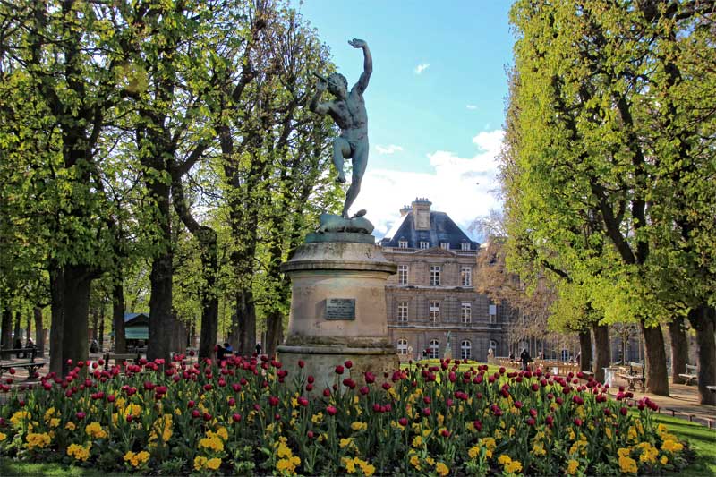 Luxembourg Gardens, Paris, statue of the Greek God Pan on a plinth surrounded by tulips